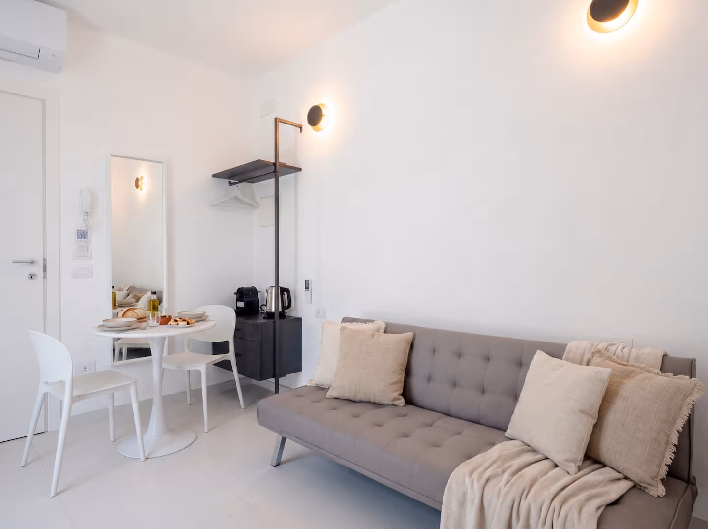 Bright whitewashed living space with kitchenette